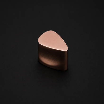 Dark textured cylindrical cabinet knob with polished brass stem