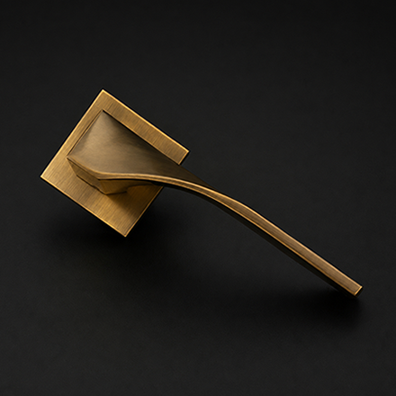 Dual-tone black textured and brass lever door handle on a round rose