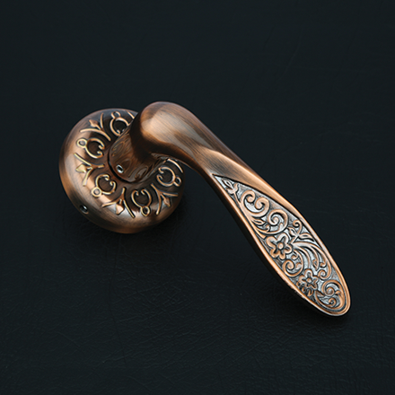 Bold brass and dark textured lever door handle on a round rose